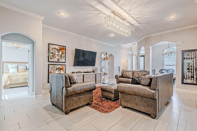 living room with an inviting chandelier, crown molding, and decorative columns