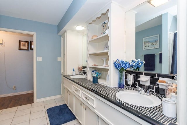 bathroom with vanity, tile patterned floors, and tasteful backsplash