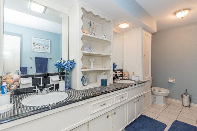 bathroom with toilet, vanity, backsplash, and tile patterned floors