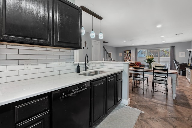 kitchen featuring dishwasher, pendant lighting, light stone counters, sink, and backsplash