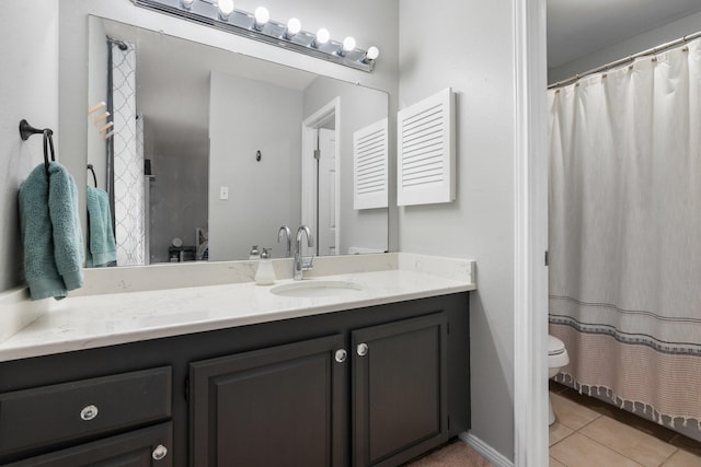 bathroom featuring tile patterned flooring, vanity, and toilet