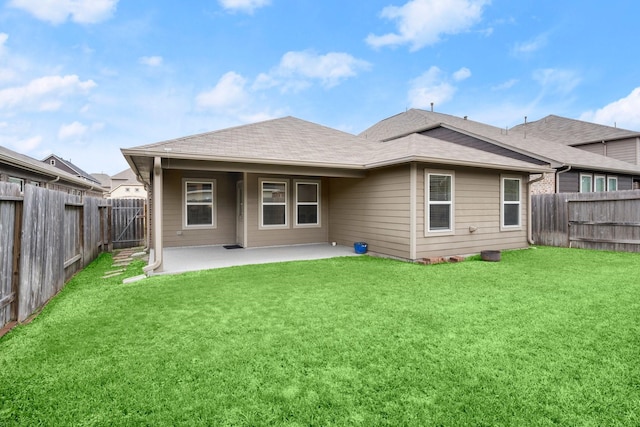 rear view of property featuring a yard and a patio