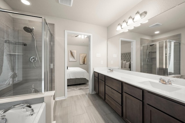 bathroom with a shower with shower door and vanity