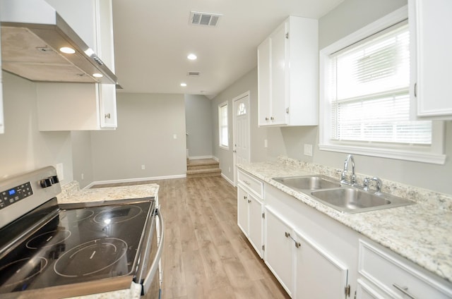 kitchen with electric range, light hardwood / wood-style floors, sink, white cabinetry, and exhaust hood