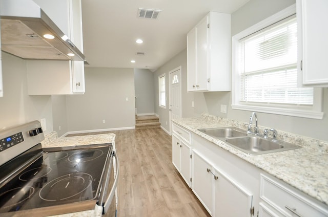 2706 Sledge St, Waller, TX 77484 - kitchen with stainless steel range with electric stovetop, ventilation hood, a sink, light wood-type flooring, and white cabinetry