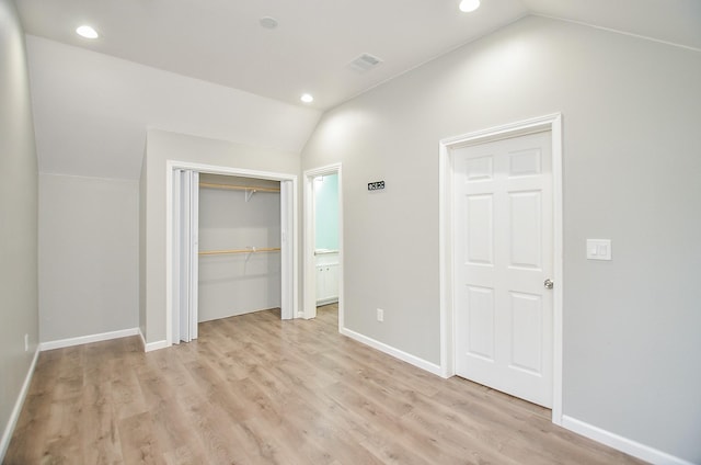 unfurnished bedroom featuring lofted ceiling and light hardwood / wood-style flooring