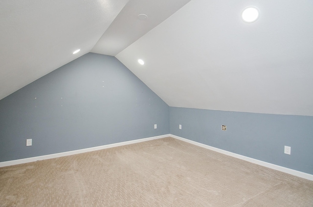 bonus room with vaulted ceiling and carpet floors