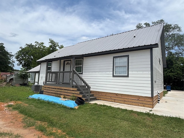 2706 Sledge St, Waller, TX 77484 - view of front facade with metal roof, a front lawn, and cooling unit