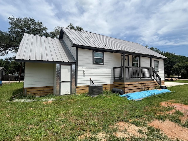 2706 Sledge St, Waller, TX 77484 - back of house with metal roof, a lawn, central AC unit, and a porch