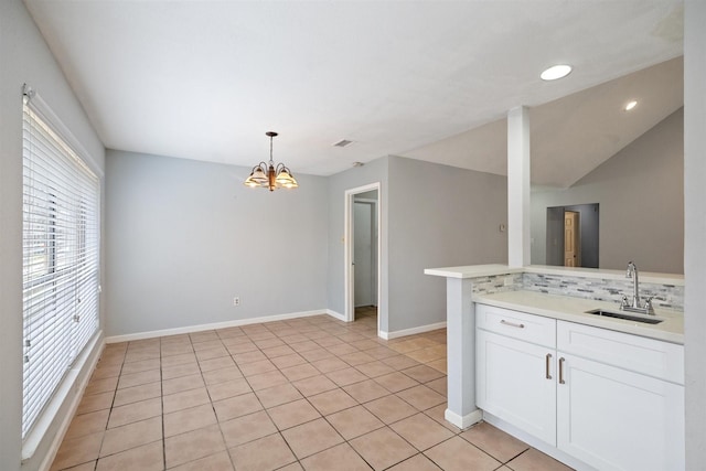 kitchen with white cabinets, a notable chandelier, pendant lighting, sink, and tasteful backsplash