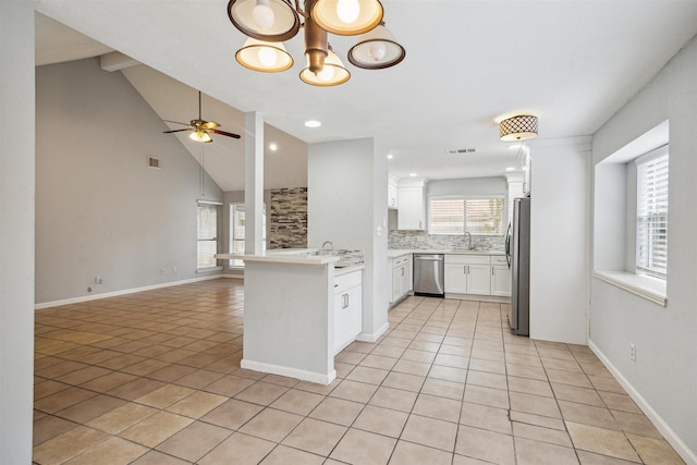 kitchen with sink, white cabinetry, lofted ceiling, kitchen peninsula, and appliances with stainless steel finishes