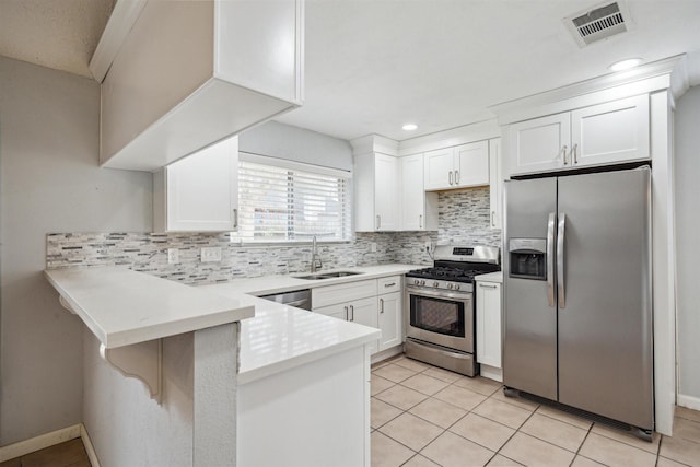 kitchen featuring appliances with stainless steel finishes, kitchen peninsula, white cabinets, and sink