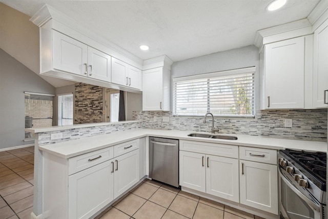 kitchen featuring white cabinets, stainless steel appliances, kitchen peninsula, light tile patterned floors, and sink