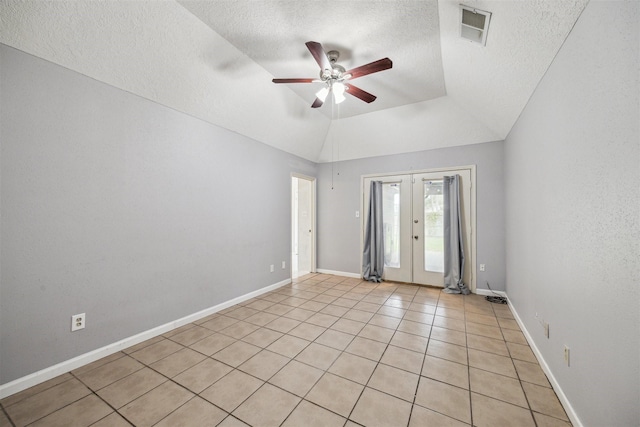 tiled spare room with ceiling fan, a textured ceiling, french doors, and a tray ceiling