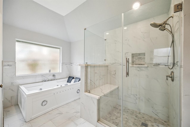 bathroom featuring shower with separate bathtub, tile walls, and vaulted ceiling