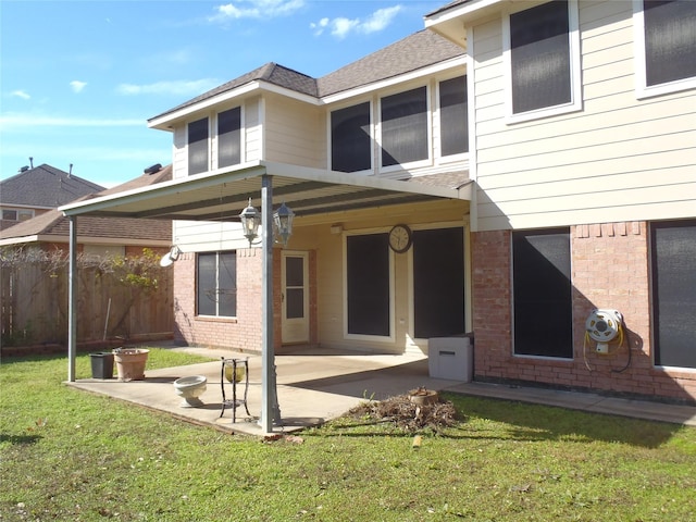 back of property with a patio area and a yard