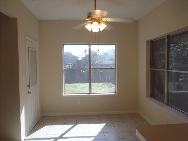 unfurnished dining area featuring ceiling fan, light tile patterned floors, and plenty of natural light