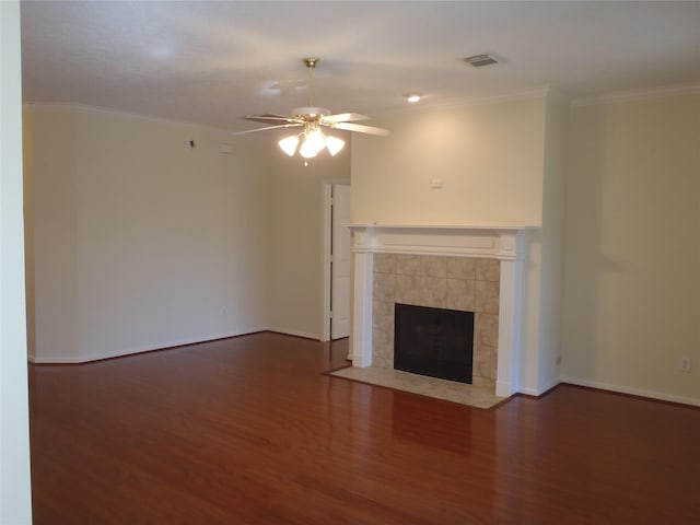 unfurnished living room with a tile fireplace, ornamental molding, ceiling fan, and dark hardwood / wood-style floors