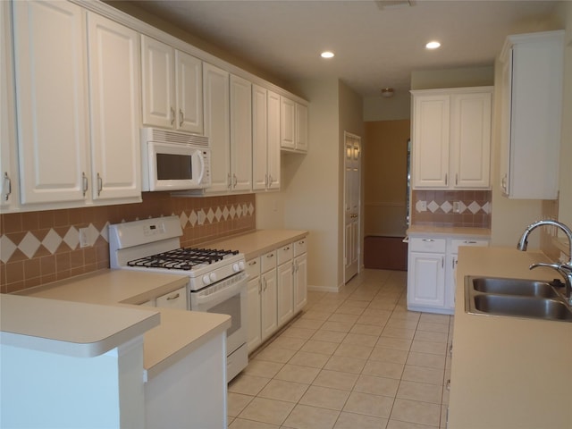 kitchen featuring white appliances, sink, and white cabinetry