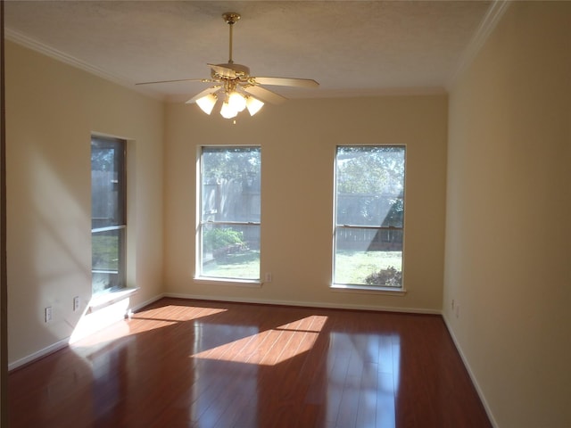 spare room with wood-type flooring, ceiling fan, crown molding, and a wealth of natural light