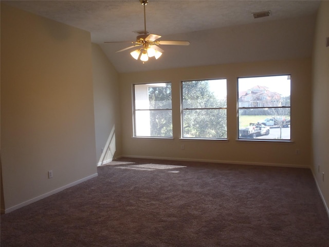 carpeted spare room featuring ceiling fan and vaulted ceiling