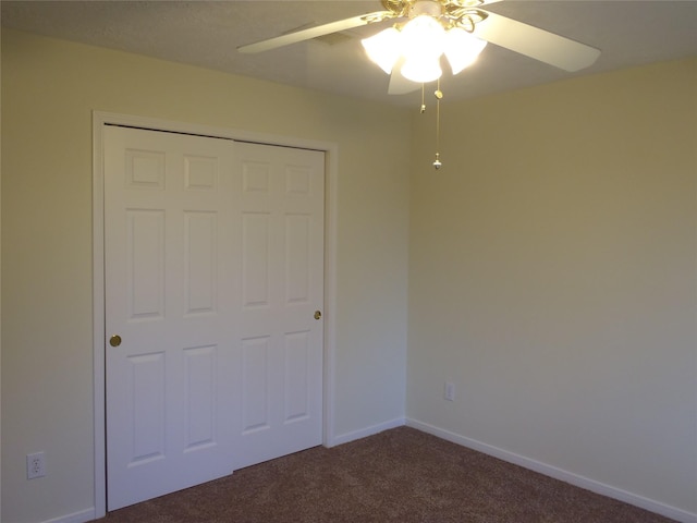 unfurnished bedroom with ceiling fan, a closet, and dark carpet