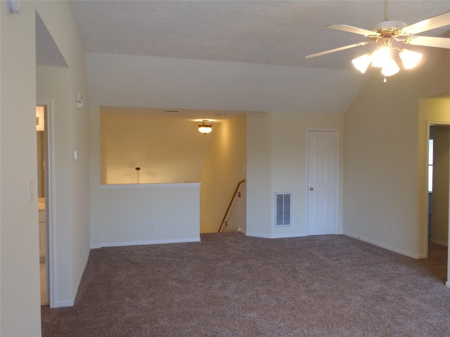 unfurnished room featuring ceiling fan, vaulted ceiling, and carpet