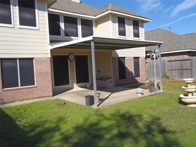 rear view of property with a lawn and a patio area