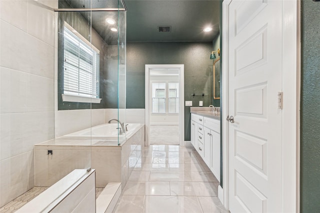 bathroom with a relaxing tiled tub and vanity