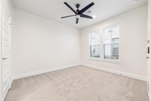 spare room with ceiling fan and light carpet