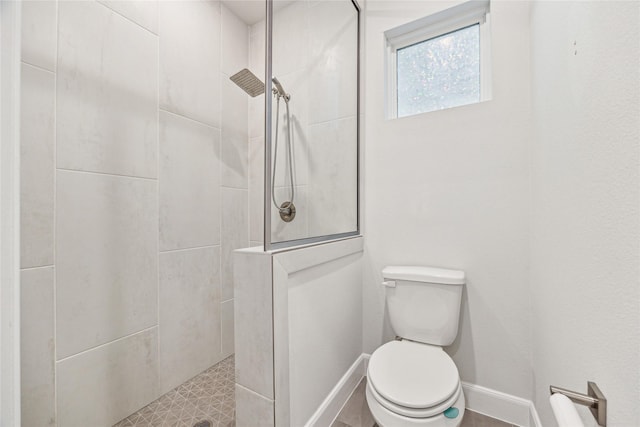 bathroom with toilet and a tile shower