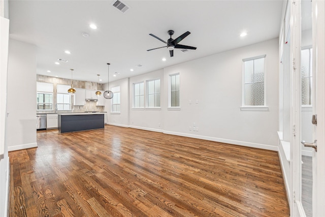 unfurnished living room with dark hardwood / wood-style flooring and ceiling fan