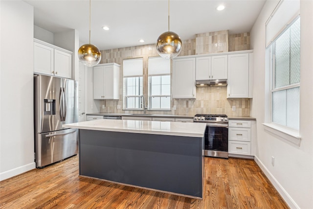 kitchen featuring decorative light fixtures, sink, appliances with stainless steel finishes, and white cabinetry