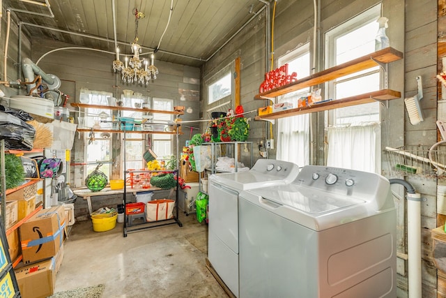 laundry area with an inviting chandelier, laundry area, and washing machine and clothes dryer