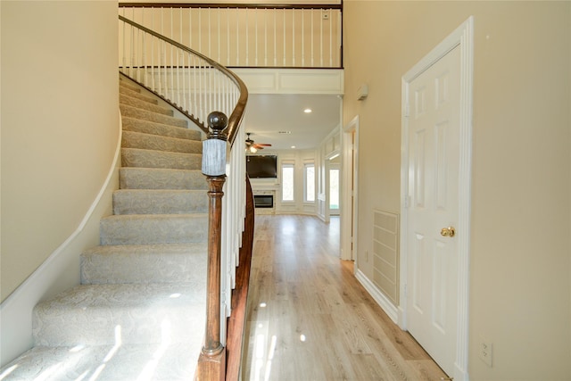 stairway featuring hardwood / wood-style flooring and ceiling fan