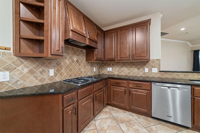 kitchen with dark stone countertops, tasteful backsplash, ornamental molding, appliances with stainless steel finishes, and light tile patterned flooring