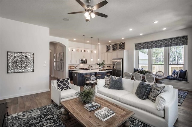 living room featuring ceiling fan and dark hardwood / wood-style flooring