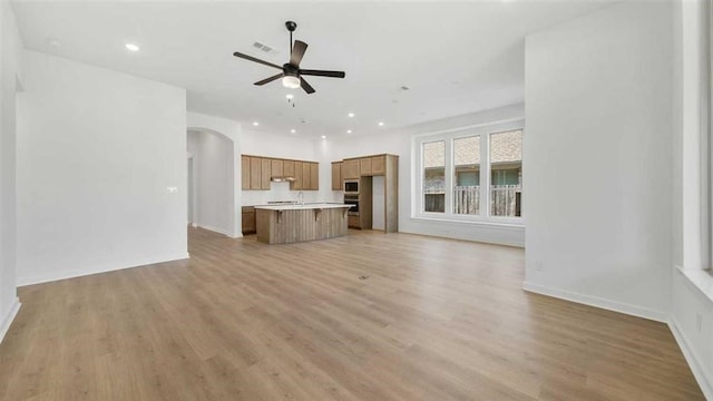 unfurnished living room featuring light hardwood / wood-style flooring and ceiling fan