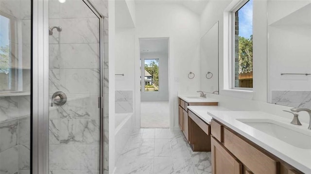 bathroom with independent shower and bath, a healthy amount of sunlight, and vanity