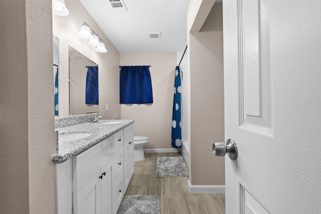 bathroom featuring vanity, hardwood / wood-style flooring, and toilet