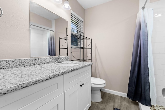 bathroom with walk in shower, vanity, and toilet