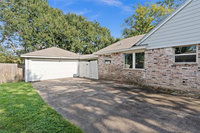 view of side of property with a garage and a lawn