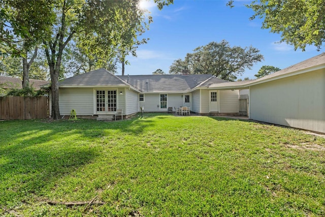 rear view of property featuring a lawn