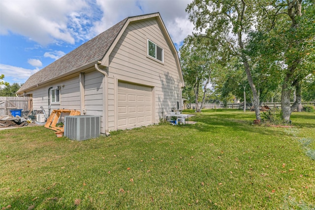 view of side of home with a garage, central air condition unit, and a lawn