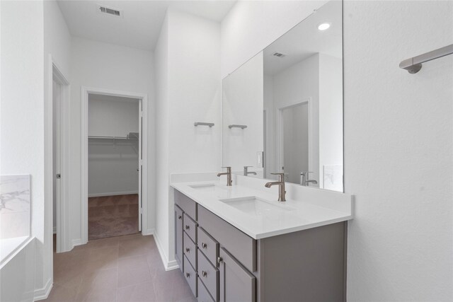 8203 Leisure Point Dr, Cypress, TX 77433 - full bath with a spacious closet, double vanity, baseboards, tile patterned flooring, and a bathtub