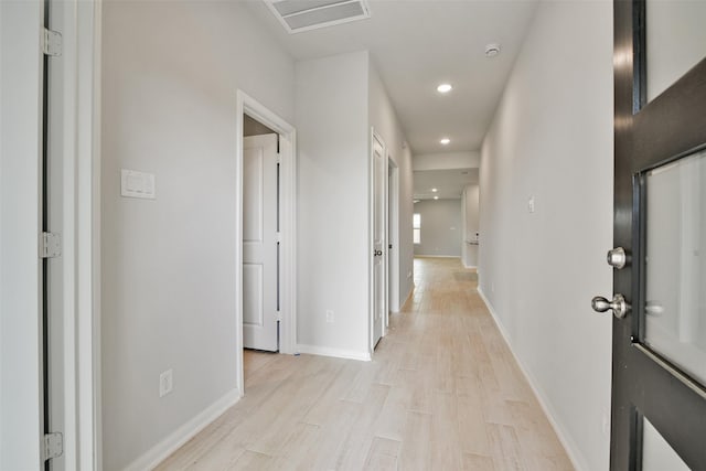 corridor with light hardwood / wood-style floors