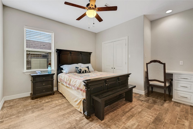 bedroom with ceiling fan, light hardwood / wood-style flooring, a closet, and built in desk