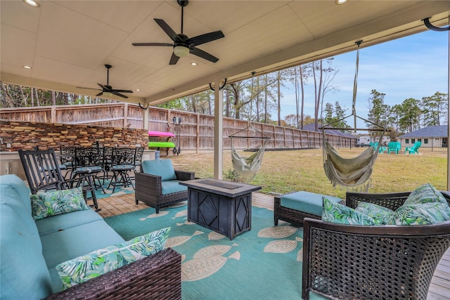 view of patio / terrace with a playground, ceiling fan, and an outdoor living space with a fire pit