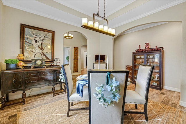 dining space with a notable chandelier, light hardwood / wood-style flooring, and crown molding