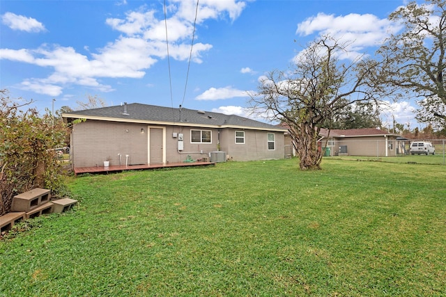 back of house with central air condition unit and a yard